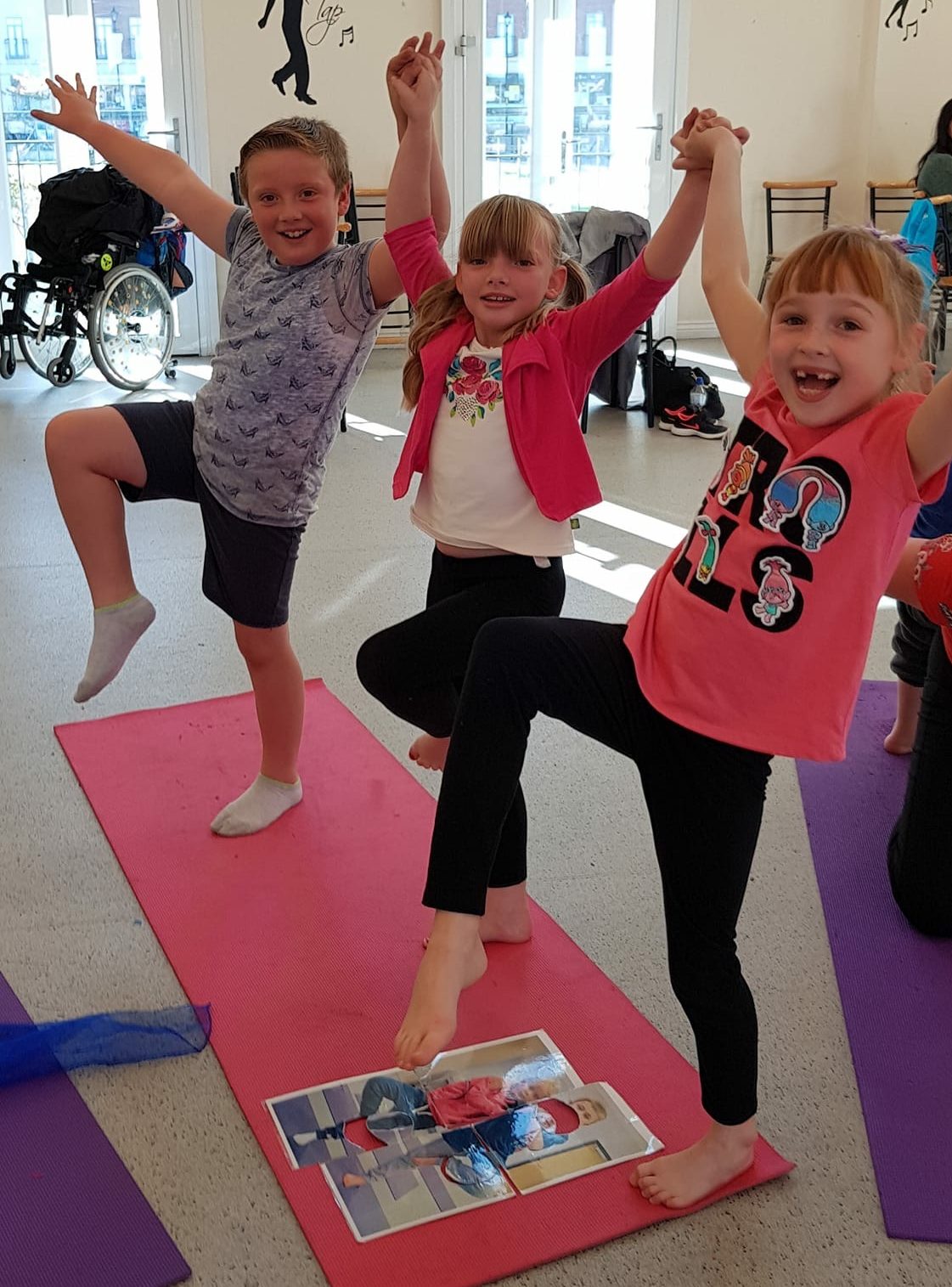 3 children balancing on one leg in yoga pose