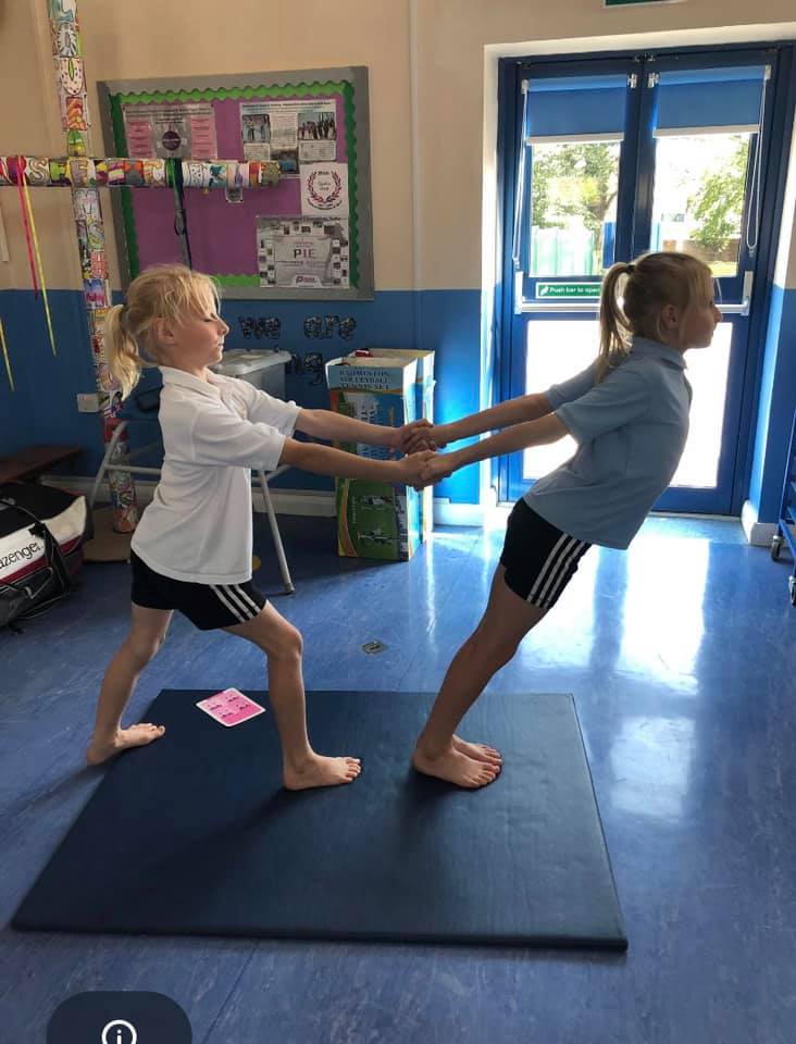two girls practicing yoga together during lunchtime at school