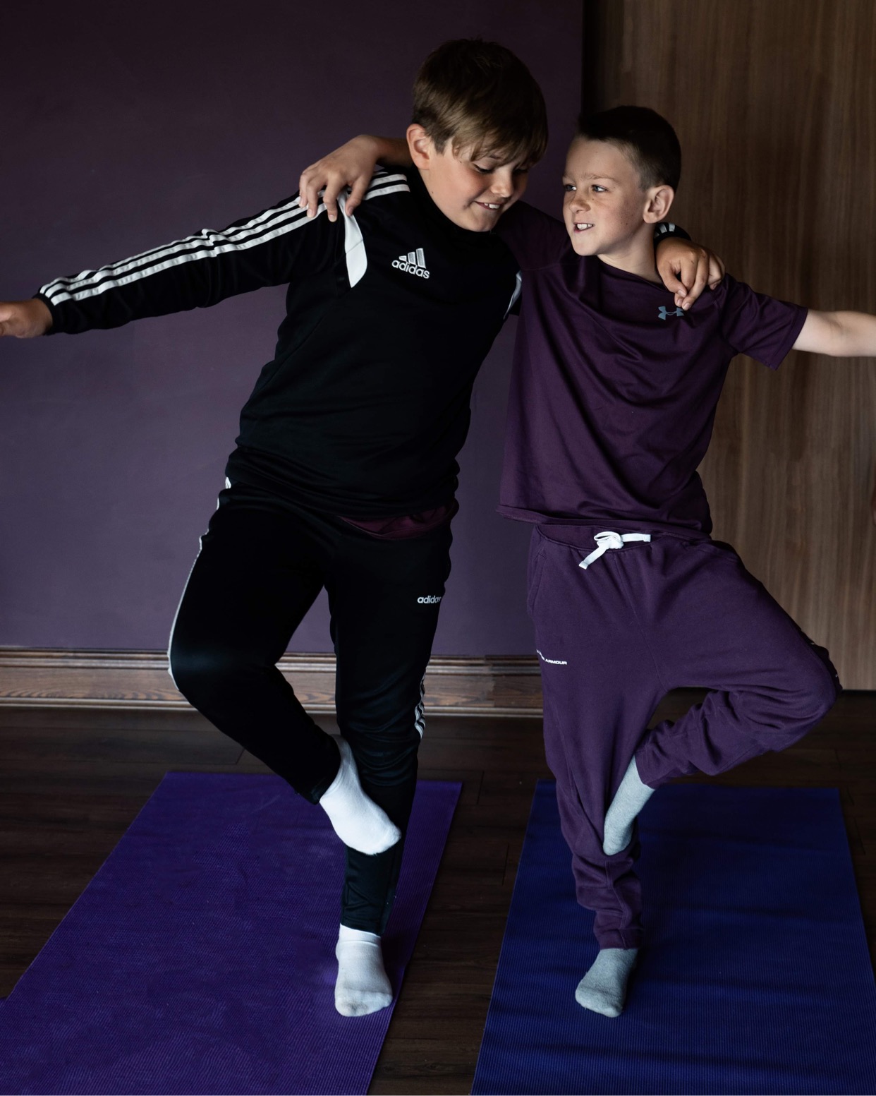two boys balancing against each other on one leg to teach support and trust