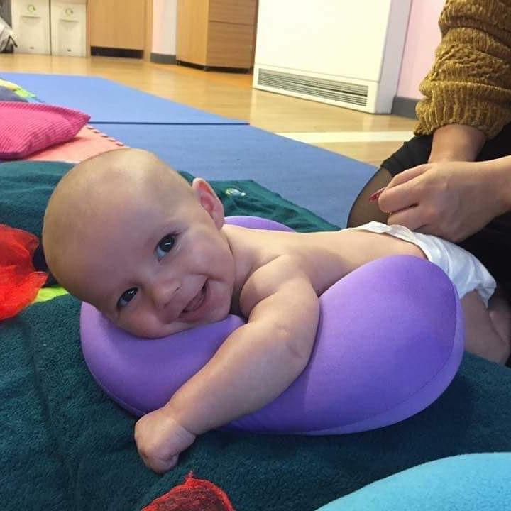 baby smiling enjoying a massage class