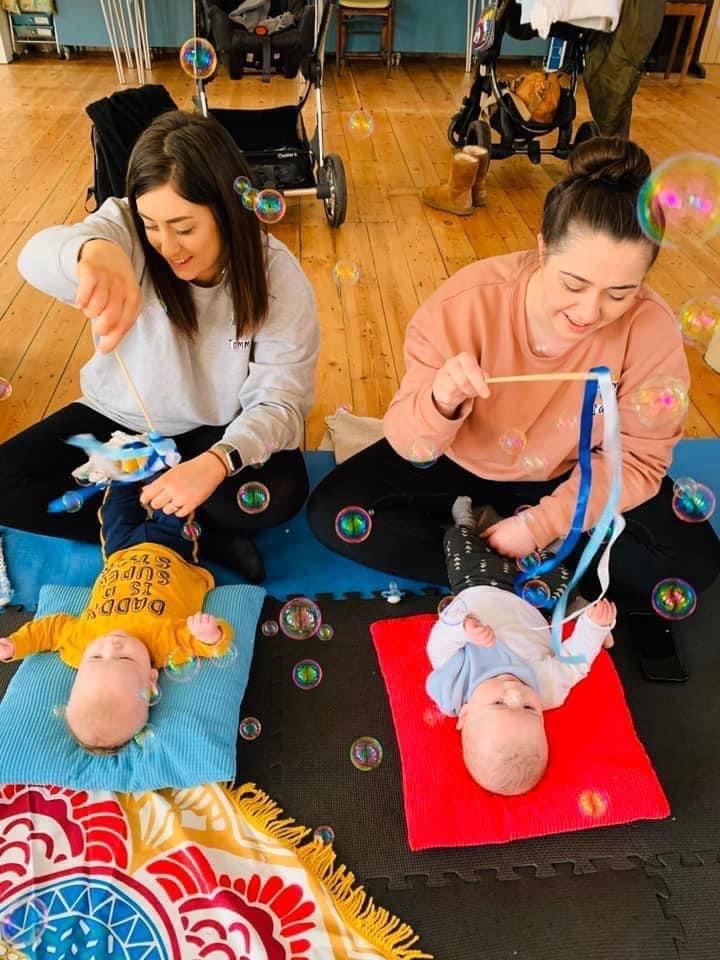two mums with babies in a yoga class with bubbles and 