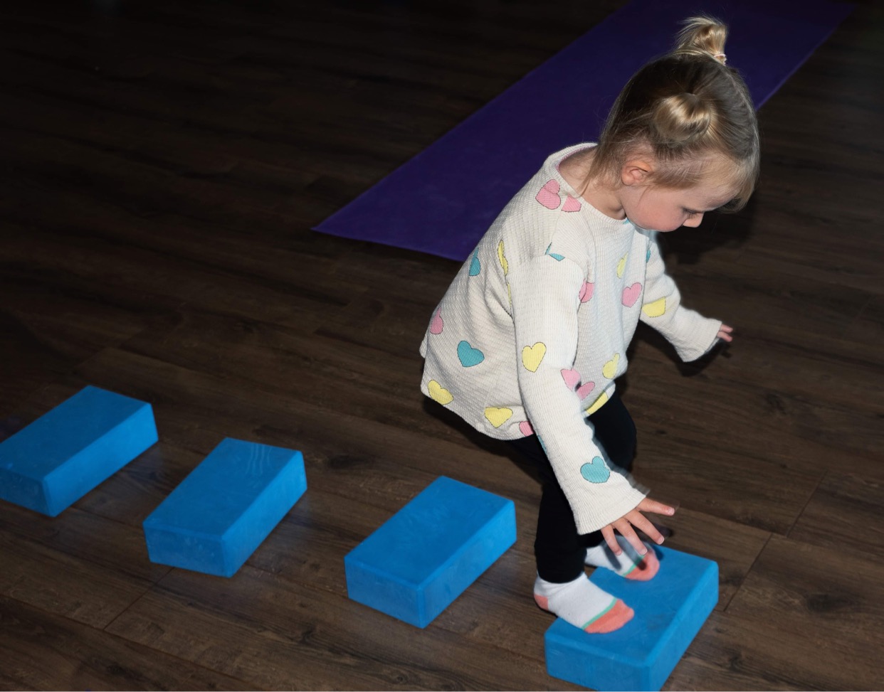 a toddler stepping on blocks like stepping stones