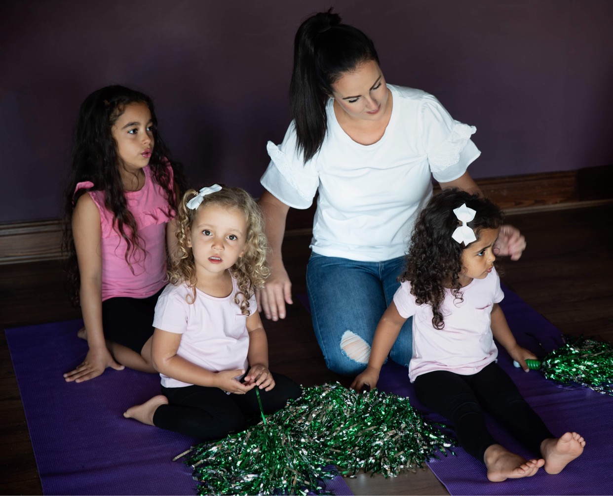 Mum with three children on yoga mats in a family yoga class 