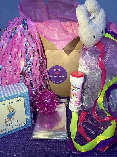 contents of the wellness boxes including a scarf, bubbles, ribbons, sensory ball, sensory foil and pom poms.  
